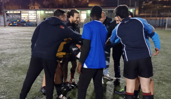 L'Ibrahima al centre de la imatge fent un xoc de mans amb jugadors dels senior masculí del Sabadell Rugby